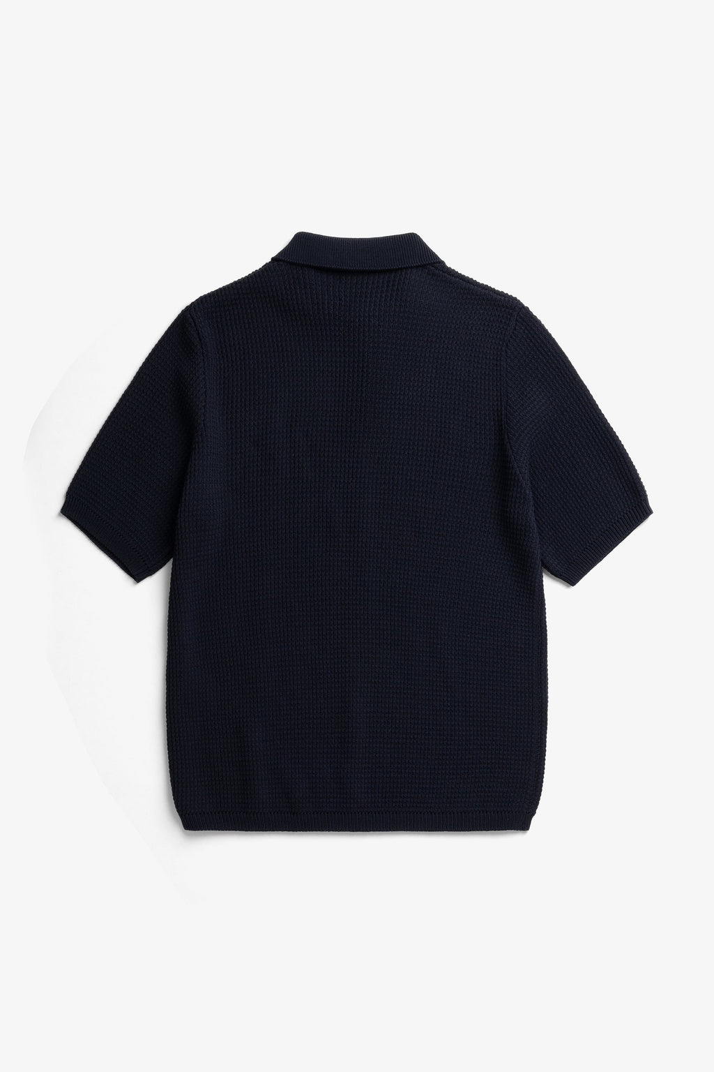 Polo en crêpe de coton – Un polo de coupe classique tricoté en fil de crêpe de coton avec un point texturé faisant référence au polo de tennis classique – Un cou…