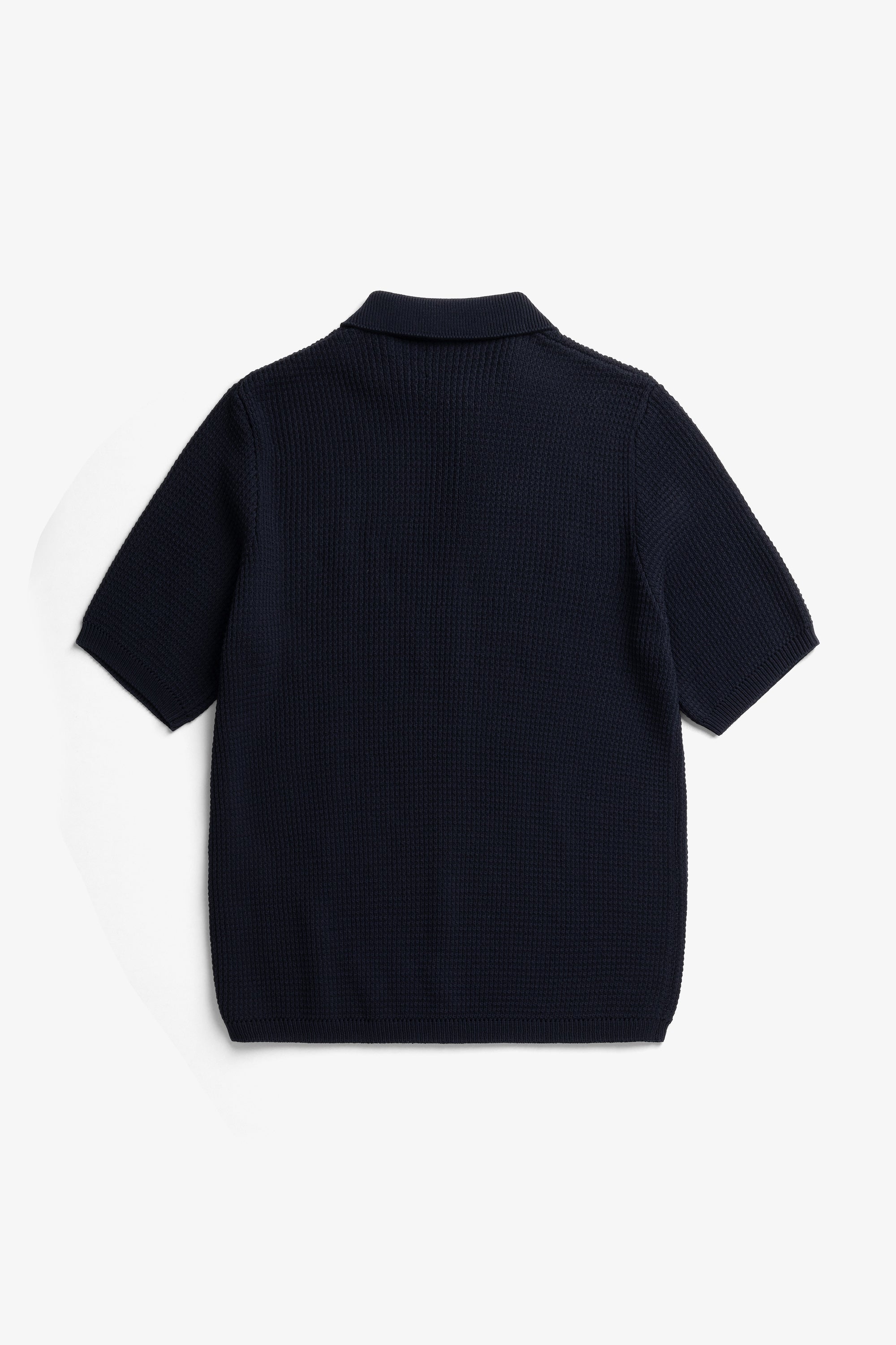 Polo en crêpe de coton – Un polo de coupe classique tricoté en fil de crêpe de coton avec un point texturé faisant référence au polo de tennis classique – Un cou…
